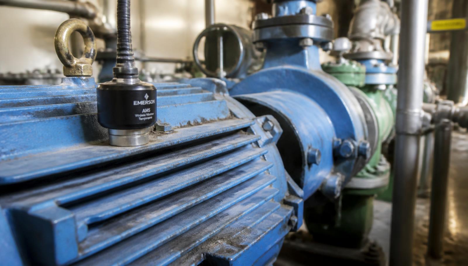 Sensor inalámbrico de vibración y temperatura montado en la carcasa de un motor eléctrico industrial que acciona una bomba